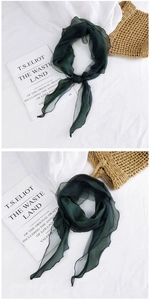 Close-up of lightweight dark green mesh scarf fabric showing delicate texture and drape