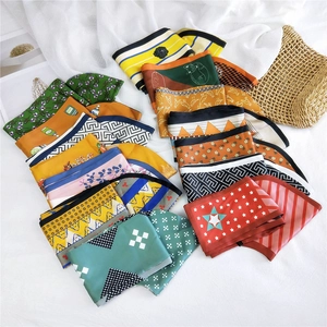 Flat lay of diverse floral and geometric silk scarves with a soft sunlit holiday vibe