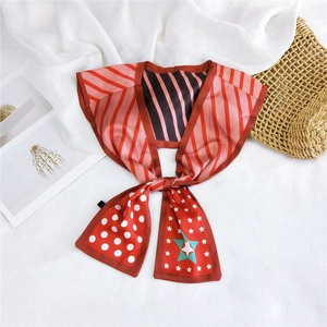 Detail of silk scarf with red stripes and polka dots on a stylish woven bag background