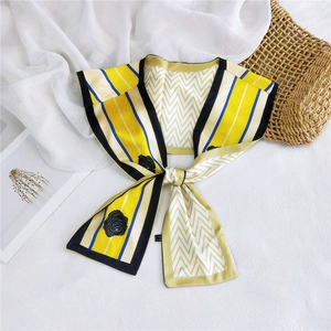 Detail of double-layer silk scarf featuring yellow stripes and black floral rose patterns
