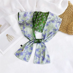 Detail of floral silk scarf with green base, purple flowers and white polka dots