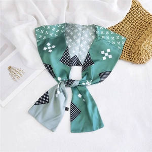 Detail of a minimalist two-tone silk scarf in green and grey with geometric patterns