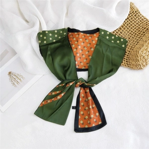 Detail of floral silk scarf with green and orange contrast on aesthetic background