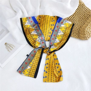 Detailed view of yellow floral silk scarf with polka dots and satin texture on white fabric