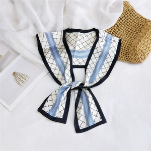Detail showing the thin silk scarf with blue stripes and black diamond pattern details