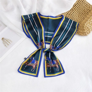 Detail of navy blue silk twilly scarf featuring horse print and striped borders