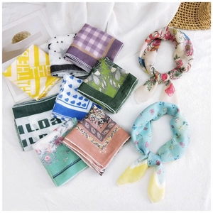 Detailed flat lay of assorted cotton linen scarves with vintage floral and plaid patterns