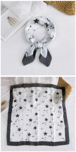 Detailed view of white cotton linen scarf with black star and moon celestial patterns