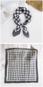 Detail view of a black and white gingham square scarf in cotton linen with knotted styling