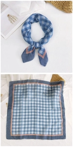 Close-up of blue checkered cotton scarf with contrast orange-pink border and soft texture