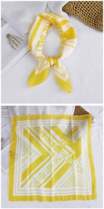 Detail of yellow and white patterned cotton linen scarf with geometric square print