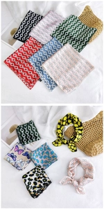 Detailed view of various printed silk scarves with chain and floral patterns