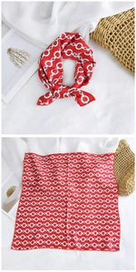 Elegant red square silk scarf featuring white chain pattern on a white linen background