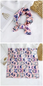 Detail of pink silk-like scarf featuring butterfly print and elegant styling