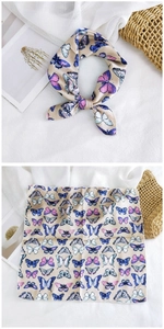 Detail of silk square scarf showing butterfly print and elegant knotted styling effect
