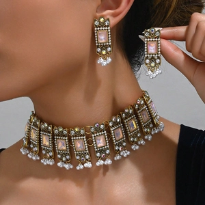 Vintage jewelry set featuring pink gemstone choker with pearl tassels and earrings