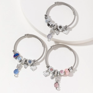 Drei Edelstahl-Kabelarmbänder mit Katzenanhängern und Liebesperlen auf weißem Sockel