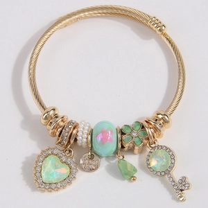 Golden bangle bracelet with heart gemstone, handmade tag, and sparkling key charm