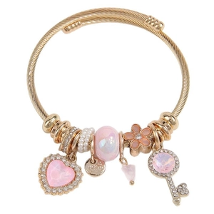Golden steel wire bracelet with crystal heart and key charms on a white background