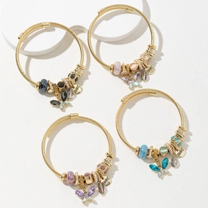 Set di quattro bracciali rigidi con farfalle e cristalli in colori assortiti e ciondoli