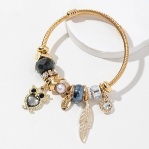 Bracelet doré torsadé avec pendentif hibou, pierres grises et perles sur support