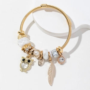 Bracelet spirale doré de style bohème avec breloques hibou, plume et cristal