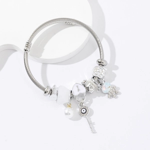 Bracelet jonc argenté avec pendentifs cœur, clé œil maléfique, perle et petit ours serti