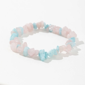 Detail of handmade elastic bracelet with natural pink quartz and blue agate chips
