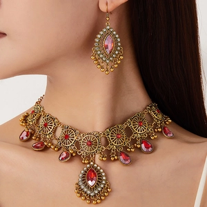 Parure de bijoux ethniques avec pierres rouges et franges dorées sur modèle