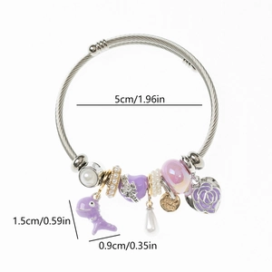 Detail of DIY charm bracelet with purple beads, dinosaur pendant, and rose heart charm