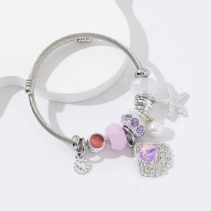 Silver steel cable bracelet with starfish, pearls and purple crystal charms on white tray
