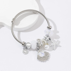 Silver stainless steel wire bracelet with starfish charms and white pearls on white stand