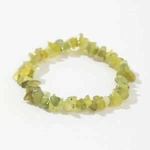 Macro shot of irregular natural green prehnite stone beads on a handmade stretch bracelet