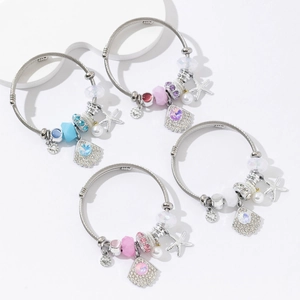Detailed view of four ocean-themed stainless steel wire bracelets with shells and starfish
