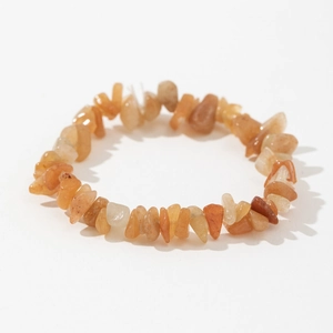 Macro shot of natural orange sunstone elastic bracelet with irregular polished crystal chips