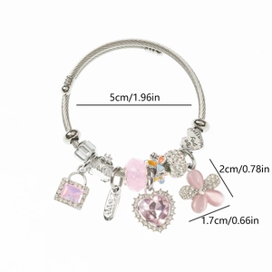 Gros plan des breloques cœur et fleur sur un bracelet perlé en acier inoxydable