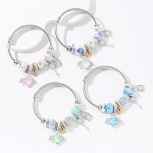 Dettagli dei braccialetti in filo d'acciaio con ciondoli a cuore, charms e lucchetti