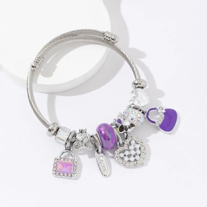 Silver steel beaded bracelet featuring purple glass charms and heart pendants on stone stand