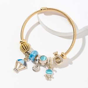 Bracelet torsadé doré avec breloques montgolfière bleue, couronne et petit ours