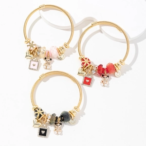 Three-piece gold spiral bracelets with heart charms and crystal beads in pink, red, and black