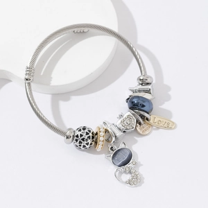 Silver beaded charm bracelet with cat pendant and Love heart charms on stone display