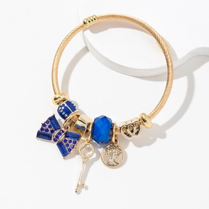 Golden steel mesh bracelet with blue rhinestone bow, life tree charm and key pendant