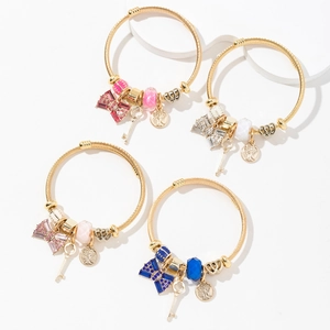 Set of four gold stainless steel wire bracelets with tree of life and bow charms