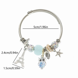 Détails des breloques tour Eiffel et hibou sur le bracelet perlé en acier inoxydable