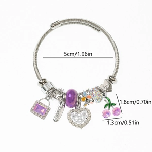 Détail d'un bracelet câble en acier avec cristaux violets et pendentifs en cœur