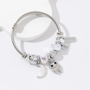 Silver beaded bangle with owl moon charms and handmade pendants on white display