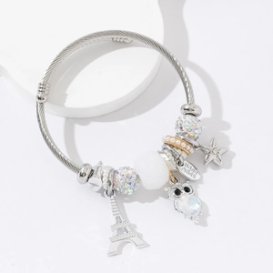 Bracelet à breloques argenté avec hibou, tour Eiffel et perle sur jonc en acier torsadé