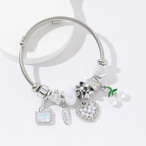 Bracelet à breloques argenté avec cœur en perles et pendentif cerise sur support blanc