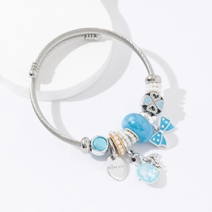 Silver twisted stainless steel bangle with blue charms and Princess pendant tag