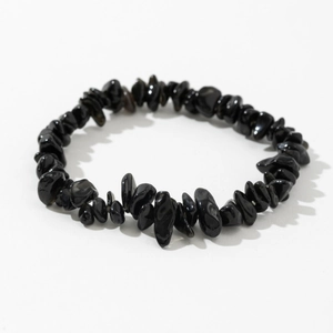 Detailed view of polished black irregular natural stone beads on an elastic bracelet
